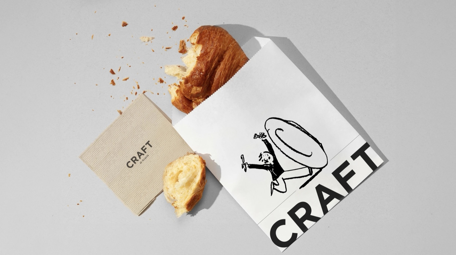 Torn croissant beside a Craft paper bag and napkin